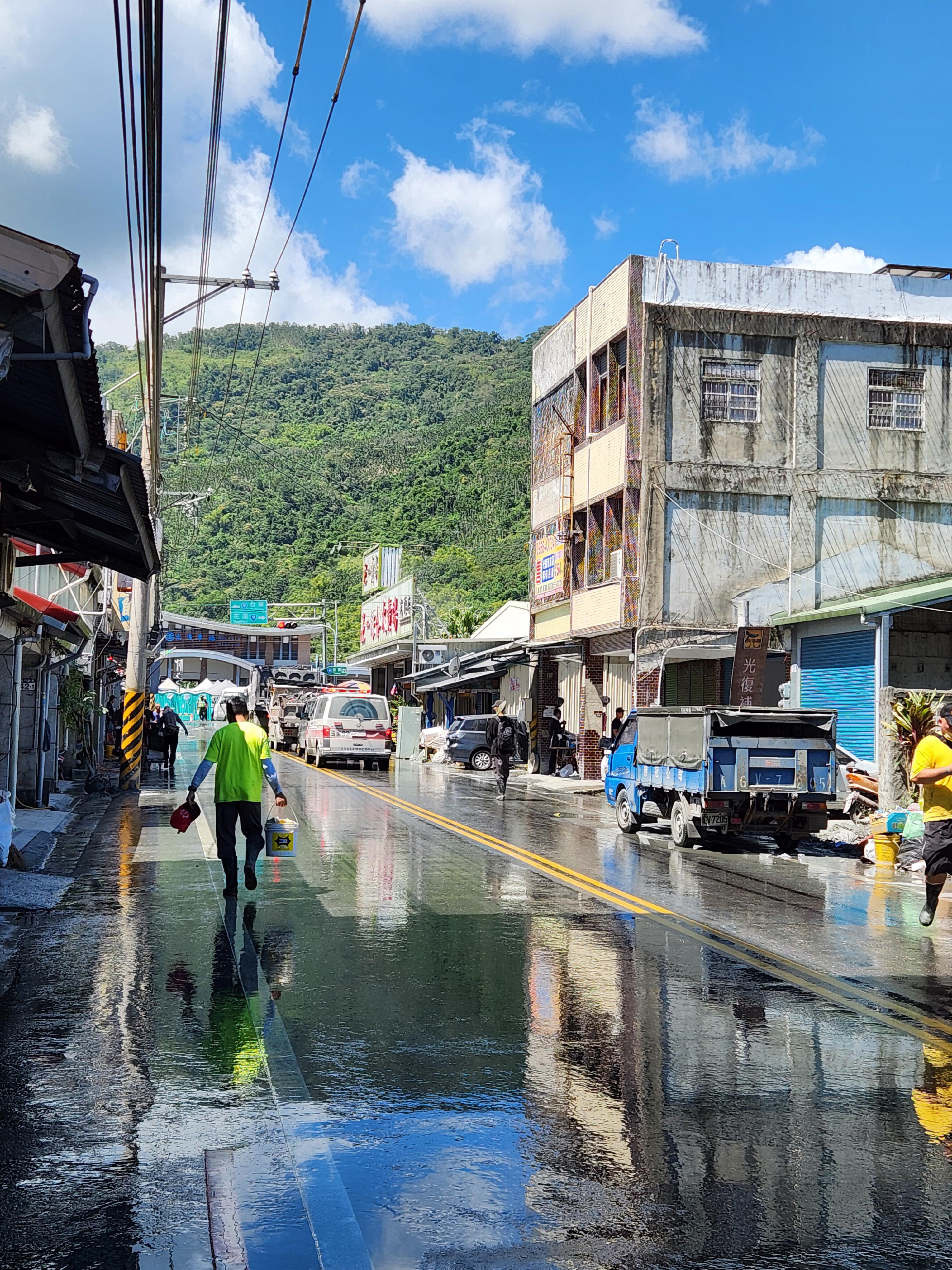 街道沖洗後反射藍天，清理工作持續進行中。
